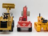 three toy construction vehicles that are sitting next to each other