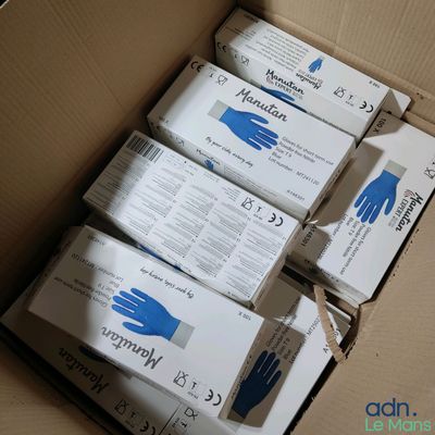 Plusieurs boîtes de gants sont rangées dans un carton.