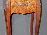 a small wooden table with a marble top on it