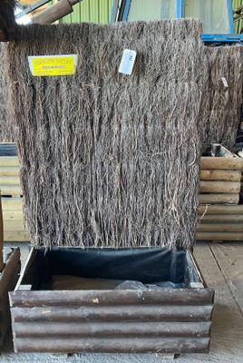 un homme qui se tient à côté d'un tas de paille