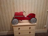 une petite voiture rouge posée sur une commode