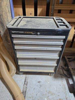 une photo d'une armoire à outils avec un tuyau à côté