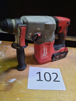 une perceuse posée sur une table à côté d'un panneau