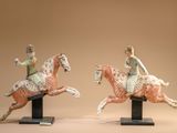 two figurines of a woman riding a horse and a man riding a horse