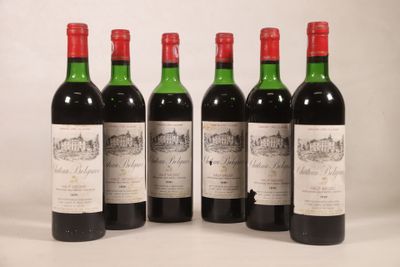 quatre bouteilles de vin sont alignées sur une surface blanche