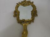 an antique mirror with a gold frame on a white surface