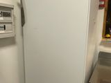 a white refrigerator in the corner of a kitchen