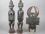 deux statues en bois représentant un homme et une femme debout l'un à côté de l'autre