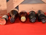 several bottles of wine are lined up on a red table