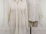 two white shirts on a mannequin stand in front of a white wall