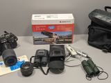 un appareil photo, un étui pour appareil photo, un sac et d'autres objets posés sur une table