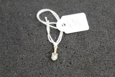 a white tag that has a small crystal on it