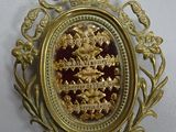 an image of a gold and red broochle with a crown on it