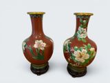 two vases with flowers painted on them on a white surface