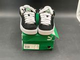 a pair of black and white shoes sitting on a green box