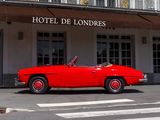a red car parked in front of a hotel