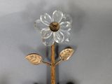 a vase with a flower on it next to a candle holder