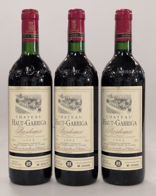 trois bouteilles de vin rouge posées sur une table blanche