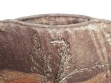 a brown vase with a tree on it sitting on a table