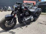 une moto noire garée sur un parking à côté d'un immeuble