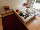 a white bed sitting in a room with a red rug on the floor