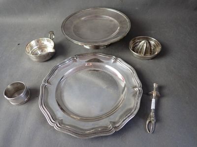 a silver plate and silver spoons on a table