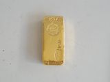 gros plan d'un lingot d'or sur une surface blanche