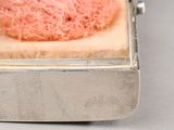 a small metal box with a piece of food inside of it