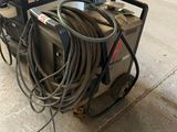 une machine posée par terre à côté de quelques câbles