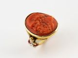 a close up of a ring with a red stone in it