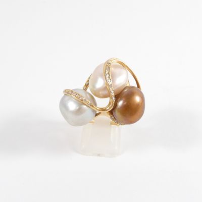 a gold ring with pearls and diamonds on a white background
