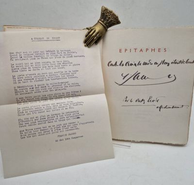 an old book with a piece of paper on top of it next to a piece of paper with a piece of writing on it