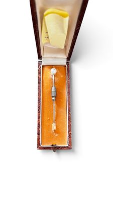 a small box with a needle in it on a white surface