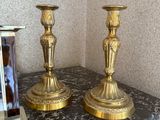deux bougies dorées posées sur une table sur laquelle se trouve une photo