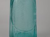 a blue glass bottle with a handle on a table