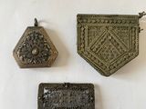trois morceaux de métal sont posés sur une surface blanche