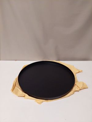 une assiette noire posée sur une table blanche