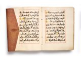 an open book with arabic writing on it sitting on top of a table