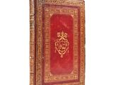 an old red book with a gold design on the cover