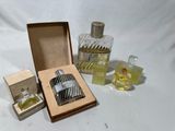 trois petits flacons de parfum et une boîte posés sur une table