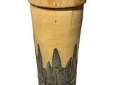 un vase jaune orné d'un motif noir