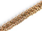 gold bracelet with a diamond cut design on a white background