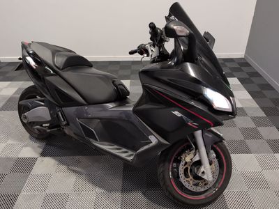 a black motorcycle parked in a room with a checkered floor