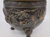 un grand bol en bronze orné d'un motif représentant un dragon