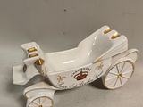 an image of a small white porcelain carriage with gold trims