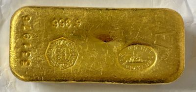 gros plan d'un lingot d'or sur une surface blanche