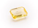 a yellow sapphire stone on a white background