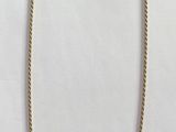 yellow and white necklace with a yellow tag on it on a white surface