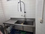 a stainless steel sink in the corner of a kitchen