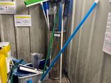 un tas de balais et d'outils dans un coin de la pièce